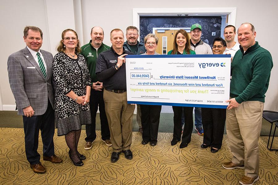 Representatives of Evergy on Thursday presented Northwest with a rebate check for its its energy-efficient projects during the last five years. Left to right are Evergy contractor Brett Sharp; Derek DeMott, capital programs engineer at Northwest; Melody Knoch, product manager at Evergy; Tyler Steele, project manager at Northwest; Carrie Koelzer, lead customer solutions manager at Evergy; Stacy Carrick, vice president of finance and administration at Northwest; Troy Brady, mechanical, electrical and plumbing supervisor at Northwest; Scott Kuhlemeyer, director of capital programs at Northwest; Jason Klindt, a member of Northwest’s Board of Regents and senior director of external affairs at Evergy; Roxanna Swaney, the chair of Northwest’s Board of Regents; and Northwest President Dr. Lance Tatum. (Photo by Lauren Adams/Northwest Missouri State University)